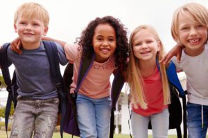 Portrait Of Excited Elementary School Pupils On Playing Field At Break Time